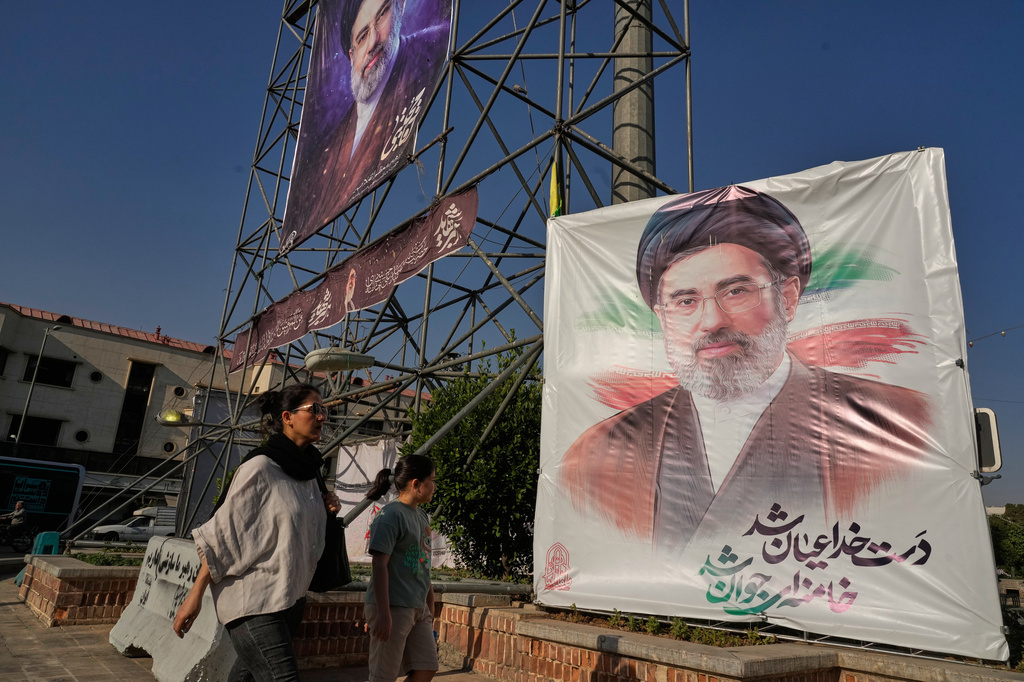 People walk past banners showing portraits of the Iranian Supreme Leader Ayatollah Mojtaba Khamenei in downtown Tehran, Iran, Monday, June 29, 2026. (AP Photo/Vahid Salemi)