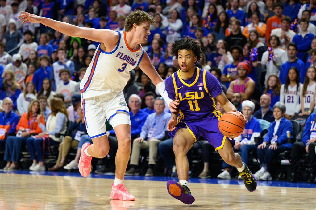 LSU guard Dedan Thomas Jr. (11) drives on Florida center Micah Handlogten (3) during the first half of an NCAA college basketball game, Tuesday, Jan. 20, 2026, in Gainesville, Fla. (AP Photo/Noah Lantor)