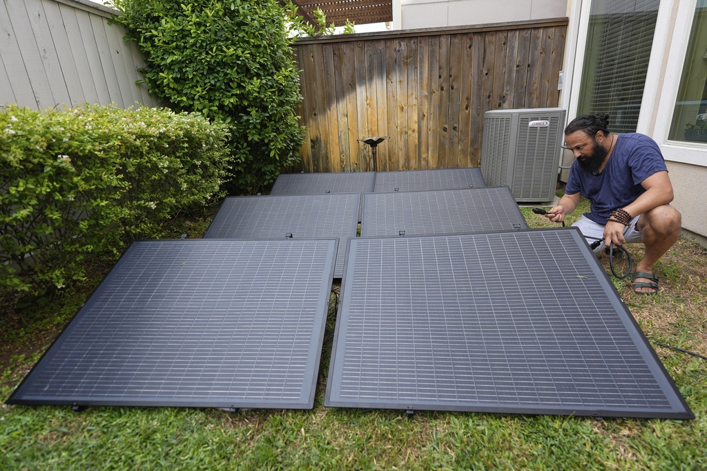 Bhavin Misra assembles a Craftstrom Solar plug-in kit at his home Tuesday, Aug. 5, 2025, in Houston. (AP Photo/David J. Phillip)