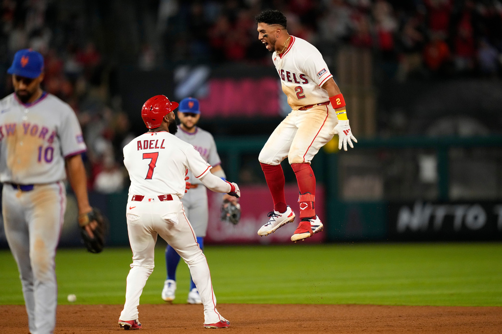 Los Angeles Angels' Oswald Peraza, right, celebrates his walk off single with Jo Adell, center, as New York Mets second baseman Marcus Semien walks off the field in the 10th inning of a baseball game Saturday, May 2, 2026, in Anaheim, Calif. (AP Photo/Mark J. Terrill)