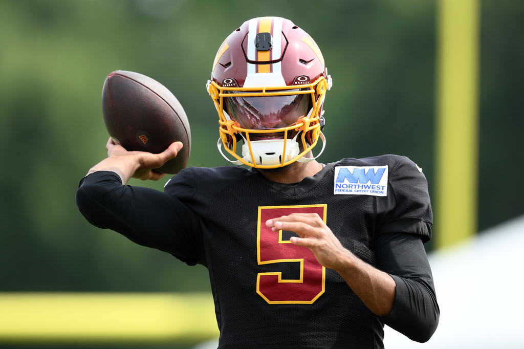 Washington Commanders quarterback Jayden Daniels works out before a joint practice with the Miami Dolphins at NFL football training camp, Wednesday, Aug. 12, 2026 in Ashburn, Va. (AP Photo/Nick Wass)