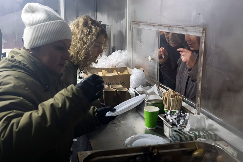 Veterans of the 3rd Separate Assault Brigade of Ukraine's Armed Forces serve free hot meals in a residential neighborhood for people without power in their homes in Kyiv, Ukraine, Saturday, Jan. 31, 2026.(AP Photo/Vladyslav Musiienko)