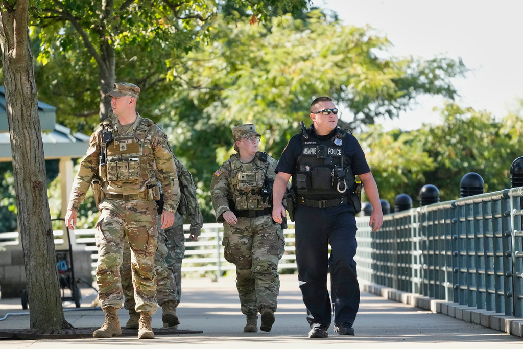 A Memphis Police Department officer, right, patrols with members of the National Guard, Friday, Oct. 10, 2025, in Memphis, Tenn. (AP Photo/George Walker IV)