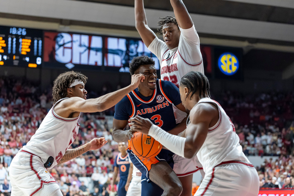 Alabama forward Amari Allen, left, forward Aiden Sherrell, top and guard Labaron Philon Jr., right, converge on Auburn forward KeShawn Murphy (3) who drives to the basket during the first half of an NCAA college basketball game Saturday, March 7, 2026, in Tuscaloosa, Ala. (AP Photo/Vasha Hunt)