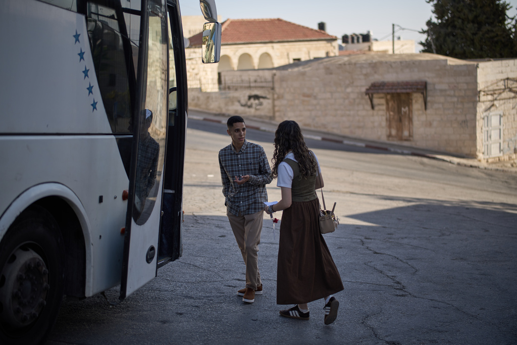 Palestinian students prepare to board a bus during the morning in the West Bank village of Taybeh, Sept. 28, 2025. (AP Photo/Leo Correa)