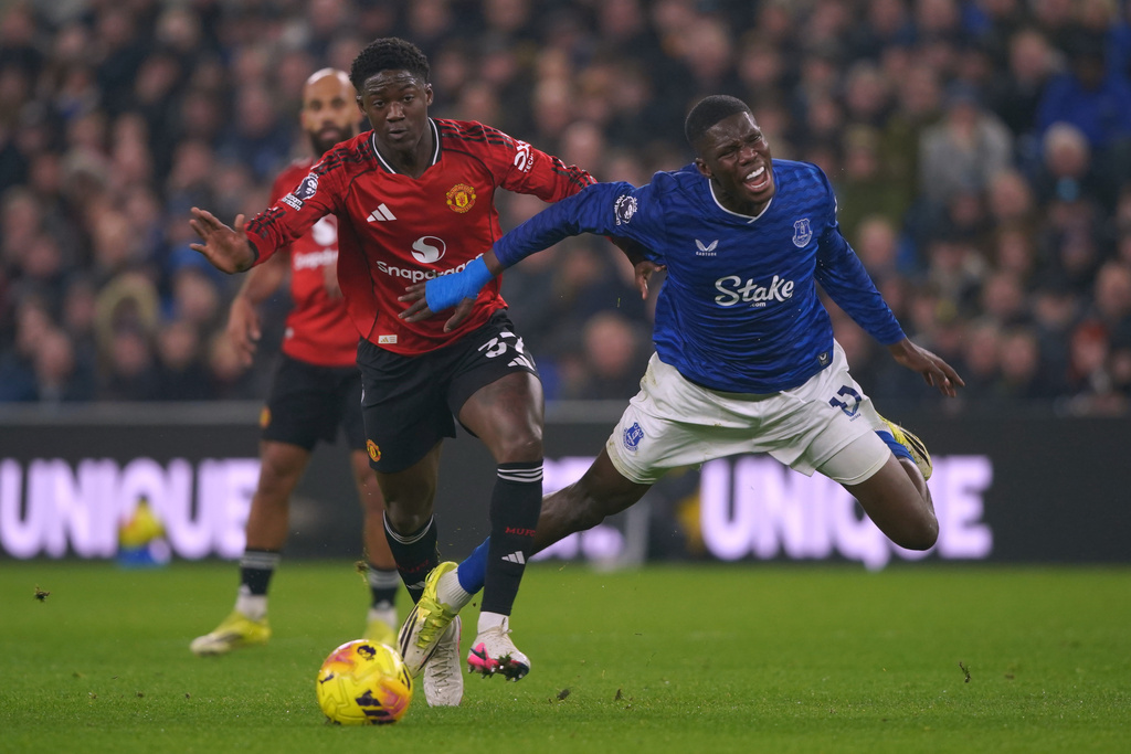 Manchester United's Kobbie Mainoo tackles Everton's Thierno Barry during the Premier League soccer match between Manchester United and Everton in Liverpool, England, Monday, Feb. 23, 2026. (AP Photo/Ian Hodgson)