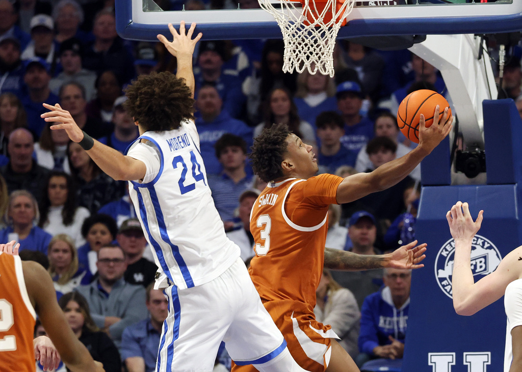 Texas' Dailyn Swain (3) shoots near Kentucky's Malachi Moreno (24) during the first second of an NCAA college basketball game in Lexington, Ky., Wednesday, Jan. 21, 2026. (AP Photo/James Crisp)