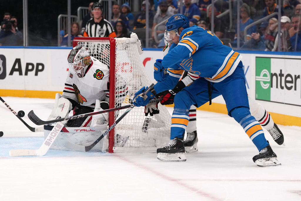 St. Louis Blues' Nick Bjugstad, right, is unable to score past Chicago Blackhawks goaltender Arvid Soderblom, right, during the second period of an NHL hockey game Wednesday, Oct. 15, 2025, in St. Louis. (AP Photo/Jeff Roberson)
