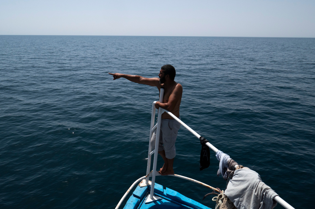 A fisherman communicates with Tunisian national guard during a search operation after a boat carrying migrants capsized off the country's southeastern coast, near Zarzis, Tunisia, Sunday, Aug. 23, 2026. (AP Photo/Bassem Aouini)