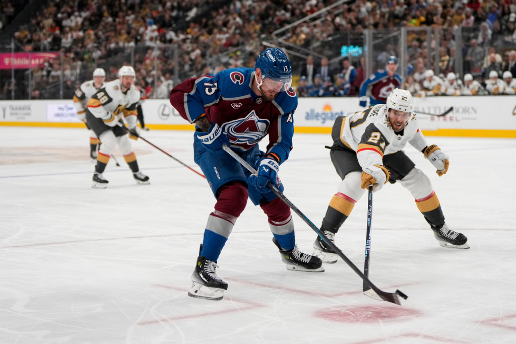 Colorado Avalanche right wing Valeri Nichushkin (13) skates with the puck against Vegas Golden Knights defenseman Shea Theodore (27) during the first period of an NHL hockey game Friday, Oct. 31, 2025, in Las Vegas. (AP Photo/Lucas Peltier)