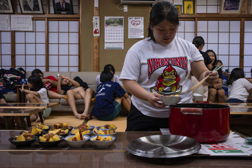 Wrestlers prepare dinner after a practice session at a sumo camp in Tottori Johoku High School in Tottori, Japan, on July 28, 2025. (AP Photo/Louise Delmotte)