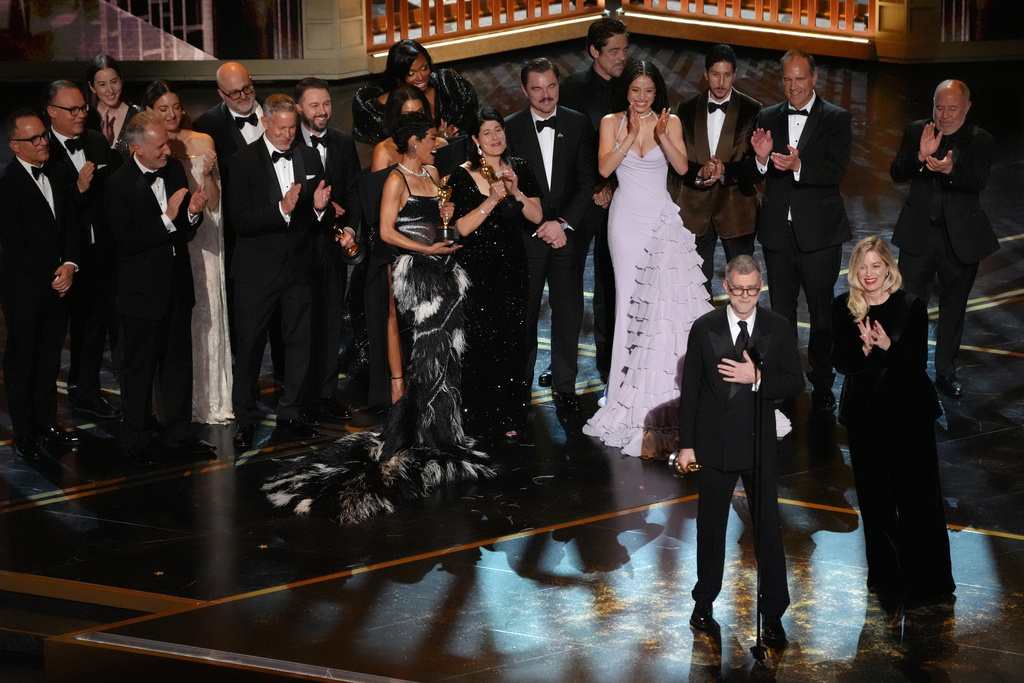 Anthony Carlino, from left, Alana Haim, Will Weiske, Florencia Martin, Andy Jurgensen, Shayna McHale, Reginal Hall, Teyana Taylor, Cassandra Kulukundis, Leonardo DiCaprio, Benicio del Toro, Chase Infiniti, Tony Villaflor, Christopher Scarabosio, Jose Antonio Garcia, Paul Thomas Anderson, and Sara Murphy accept the award for best picture for "One Battle After Another" during the Oscars on Sunday, March 15, 2026, at the Dolby Theatre in Los Angeles. (AP Photo/Chris Pizzello)