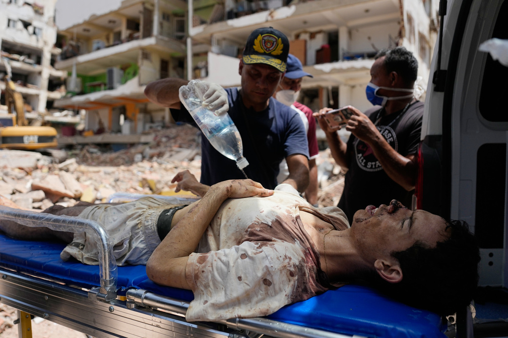 Rescue workers load Daniel Cordero onto an ambulance after pulling him from the rubble of his home two days after an earthquake struck Catia La Mar, Venezuela, Friday, June 26, 2026. (AP Photo/Fernando Vergara)