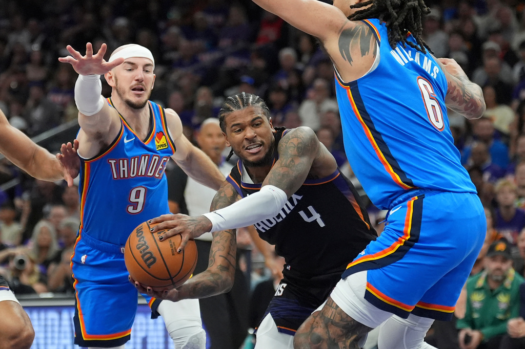 Phoenix Suns guard Jalen Green (4) tries to drive to the basket between Oklahoma City Thunder guard Alex Caruso (9) and Thunder forward Jaylin Williams (6) during the first half of Game 3 of a first-round NBA playoffs basketball series, Saturday, April 25, 2026, in Phoenix. (AP Photo/Ross D. Franklin)