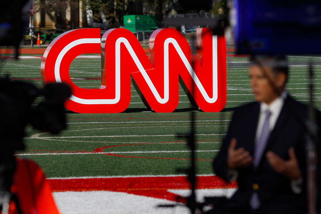 FILE - A journalist records video near a CNN sign on an athletic field outside the Clements Recreation Center where the CNN/New York Times will host the Democratic presidential primary debate at Otterbein University, Monday, Oct. 14, 2019, in Westerville, Ohio. (AP Photo/John Minchillo, File)