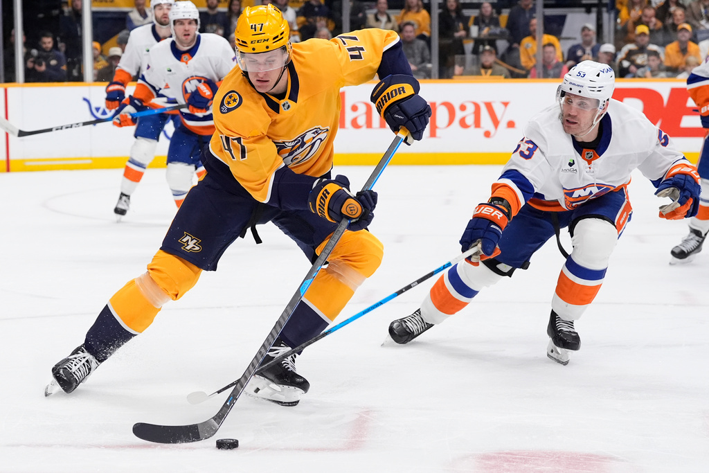 Nashville Predators right wing Michael McCarron (47) skates the puck past New York Islanders center Casey Cizikas (53) during the second period of an NHL hockey game Thursday, Jan. 8, 2026, in Nashville, Tenn. (AP Photo/George Walker IV)