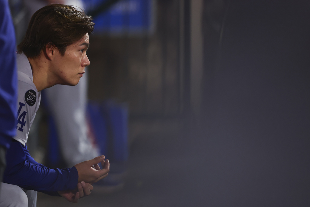 Los Angeles Dodgers pitcher Yoshinobu Yamamoto looks on from the dugout during the fifth inning of a baseball game against the Los Angeles Angels, Monday, Aug. 11, 2025, in Anaheim, Calif. (AP Photo/Jessie Alcheh)