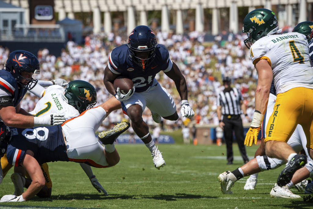 Virginia running back Harrison Waylee (21) evades William & Mary cornerback Jalen Jones (2) and scores a touchdown during the first half of an NCAA college football game Saturday, Sept. 13, 2025, in Charlottesville, Va. (AP Photo/Mike Caudill)