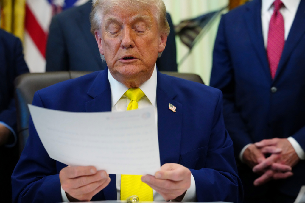 President Donald Trump looks at a document at an event about coal, Thursday, June 4, 2026, in the Oval Office of the White House in Washington. (AP Photo/Julia Demaree Nikhinson)