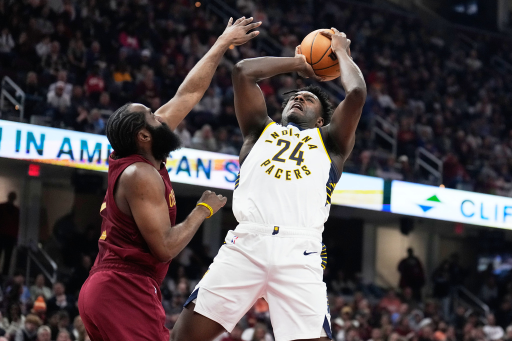 Indiana Pacers guard Kobe Brown (24) shoots as Cleveland Cavaliers guard James Harden, left, defends in the first half of an NBA basketball game in Cleveland, Sunday, April 5, 2026. (AP Photo/Sue Ogrocki)