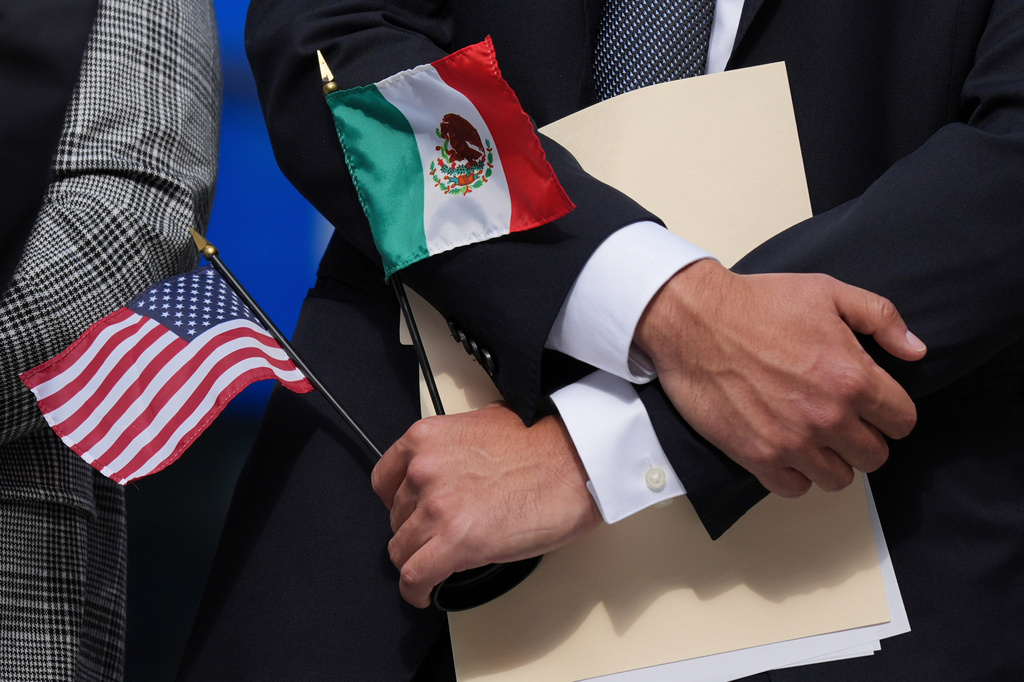FILE - A person holds an American flag and a Mexico flag at a news conference, in Chicago, Sept. 4, 2025. (AP Photo/Nam Y. Huh, File)