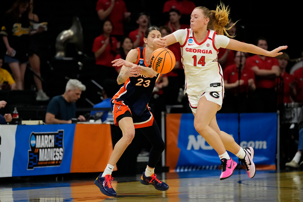 Georgia guard Rylie Theuerkauf (14) steals the ball from Virginia guard Romi Levy (23) during the first half in the first round of the NCAA college basketball tournament, Saturday, March 21, 2026, in Iowa City, Iowa. (AP Photo/Charlie Neibergall)