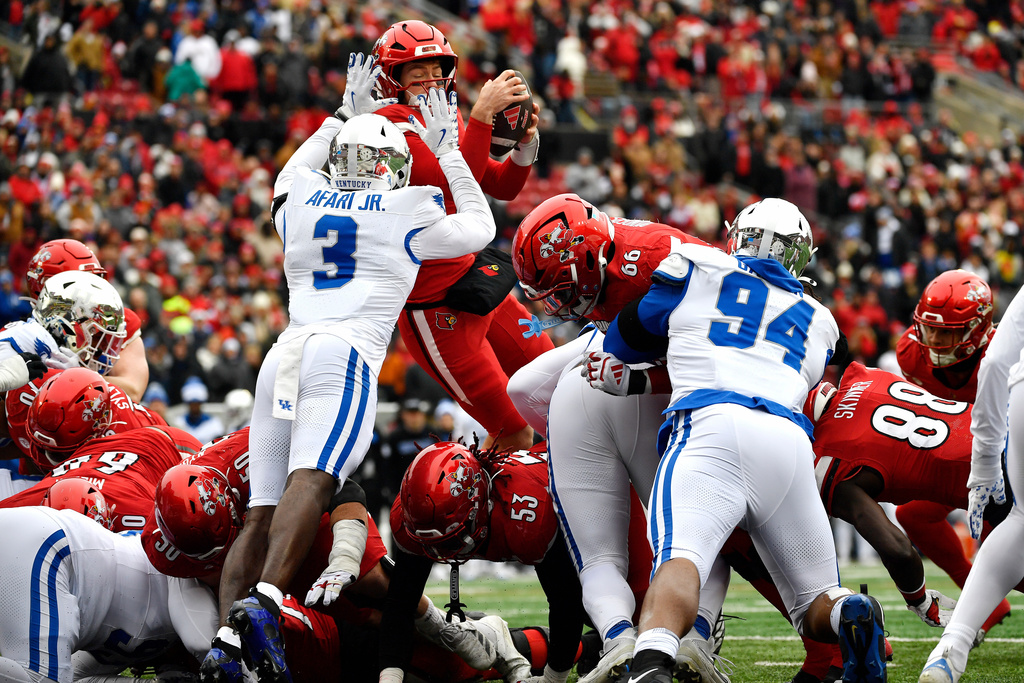Louisville quarterback Miller Moss (7) dives over the Kentucky line to score during the first half of an NCAA college football game in Louisville, Ky., Saturday, Nov. 29, 2025. (AP Photo/Timothy D. Easley)