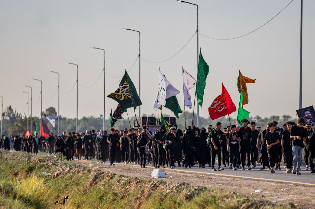 Shiite pilgrims march to Karbala, to observe Arbaeen that marks the end of a 40-day mourning period following the Day of Ashura, in Najaf, Iraq, Tuesday, July 28, 2026. (AP Photo/Anmar Khalil)