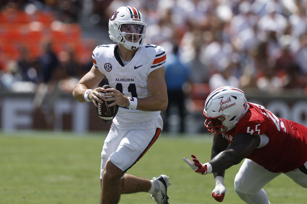 Auburn quarterback Jackson Arnold (11) scrambles away from South Alabama defensive lineman Ed Smith IV (45) during the first half of an NCAA college football game, Saturday, Sept. 13, 2025, in Auburn, Ala. (AP Photo/Butch Dill)