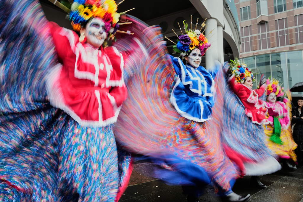Women dance as they take part in the traditional Catrina parade marking the Day of the Dead in Frankfurt, Germany, Saturday, Nov. 1, 2025. (AP Photo/Michael Probst)