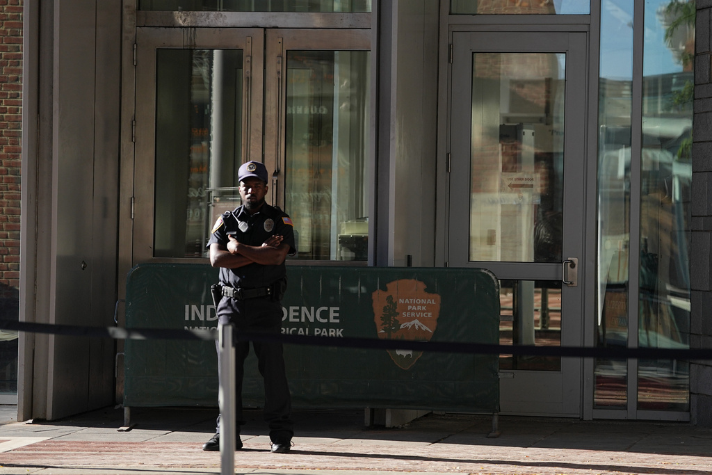 A guard stands at the entrance to The Liberty Bell center that is closed due to a government shutdown in Philadelphia, Wednesday, Oct. 1, 2025. (AP Photo/Matt Rourke)