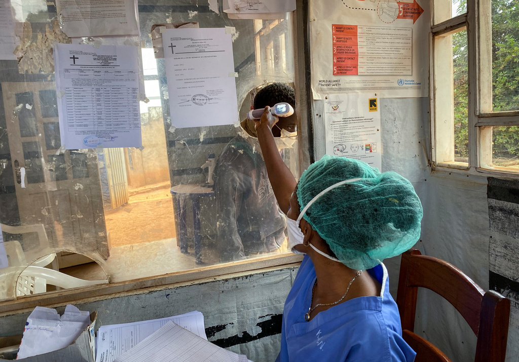 FILE - A medical worker checks a person's temperature at the Matanda Hospital in Butembo, where the first case of Ebola died, in the North Kivu province of Congo, Feb. 11, 2021. (AP Photo/Al-hadji Kudra Maliro)