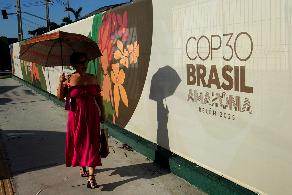 A woman walks past a sign for the COP30 U.N. Climate Summit, in Belem, Para state, Brazil, Tuesday, November 4, 2025. (AP Photo/Eraldo Peres)