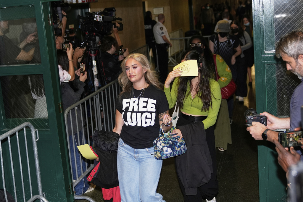 Members of the public, including a woman wearing a "Free Luigi" shirt, enter a courtroom before Luigi Mangione is escorted into the courtroom in New York on Tuesday, Sept. 16, 2025. (AP Photo/Seth Wenig)
