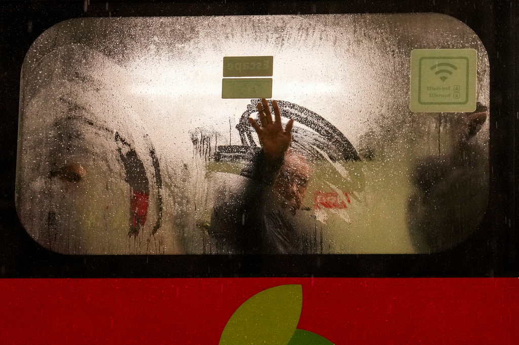 A man on a bus wipes frost from the window during a rainstorm in Santiago, Chile, early Monday, July 20, 2026. (AP Photo/Esteban Felix)