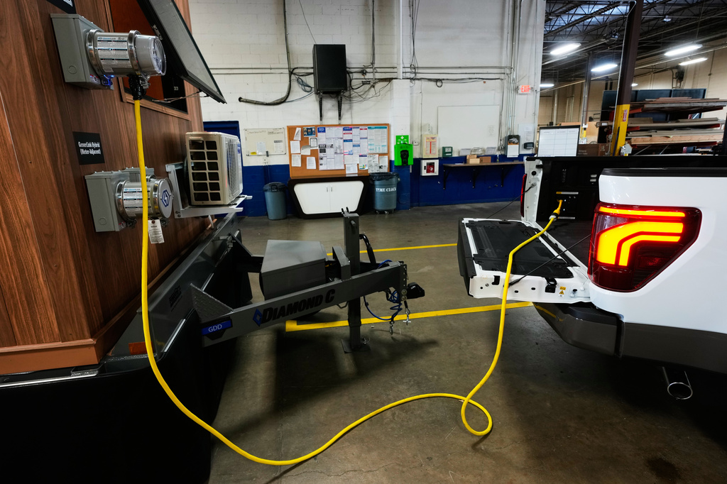 A one-foot long adapter is shown connected to a 240-volt outlet onboard a Ford F-150 King Ranch, Wednesday, July 22, 2026, in Southgate, Mich. The adapter makes the vehicle compatible to plug into a longer, separate cable that connects to a transfer switch installed directly on one's electric meter. (AP Photo/Paul Sancya)