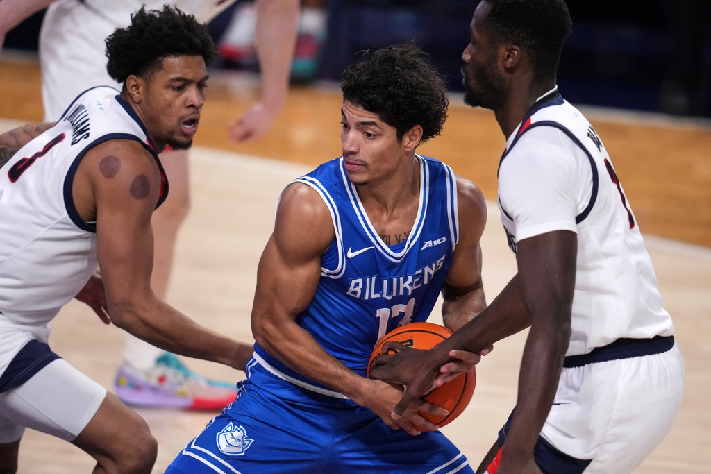 Saint Louis guard Dion Brown, center, is defended by Duquesne guard Jimmie Williams, left, and David Dixon during the first half of an NCAA college basketball game in Pittsburgh, Tuesday, Jan. 20, 2026. (AP Photo/Gene J. Puskar)