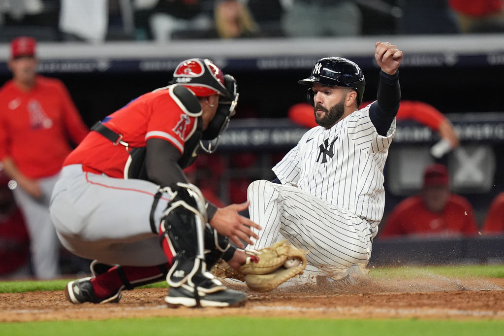 New York Yankees' Austin Wells slides past Los Angeles Angels catcher Logan O'Hoppe to score on a double by José Caballero during the ninth inning of a baseball game Wednesday, April 15, 2026, in New York. (AP Photo/Frank Franklin II)