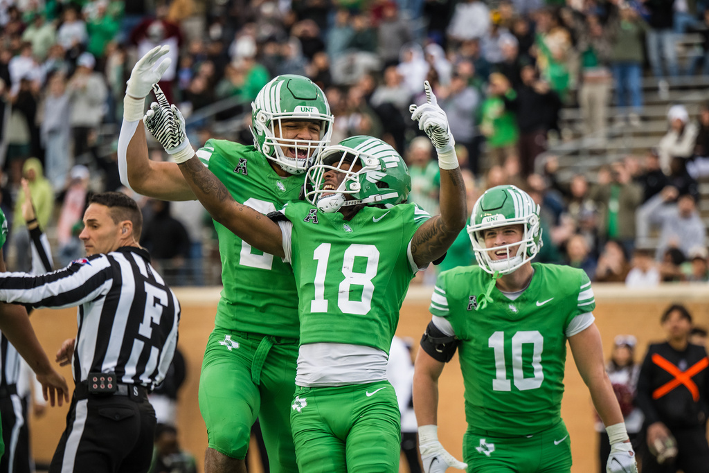North Texas wide receiver Terrence Lewis (18) celebrates after a touchdown with Caleb Hawkins, center left, and Wyatt Young (10) during an NCAA college football game against Temple, Friday, Nov. 28, 2025, Denton, Texas. (AP Photo/Jessica Tobias)