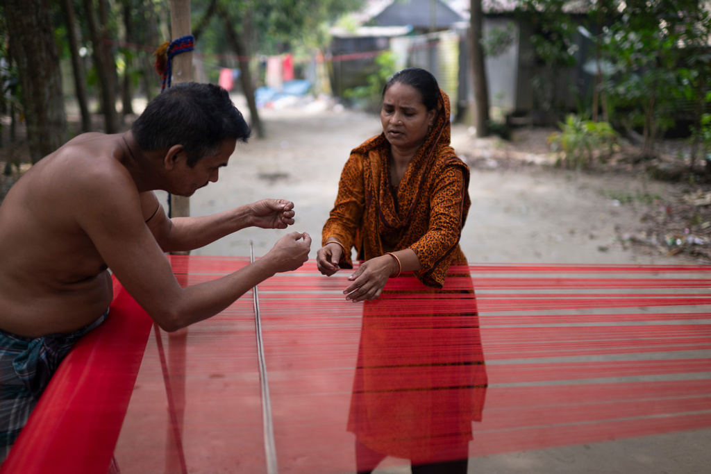 Handloom weavers arrange threads at a weaving workshop in Tangail District, Bangladesh, Nov. 5, 2025. (AP Photo/Mahmud Hossain Opu)
