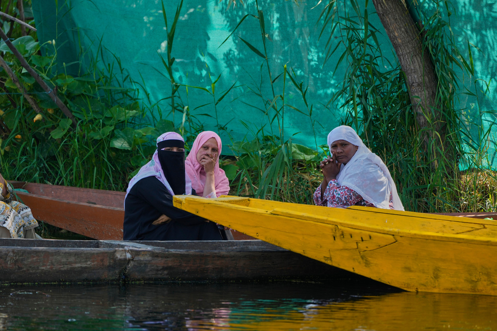 Kashmiri Shiite Muslim women watch during a Muharram procession in the interior of Dal Lake on the outskirts of Srinagar, Indian controlled Kashmir, Thursday, June 25, 2026. (AP Photo/Mukhtar Khan)