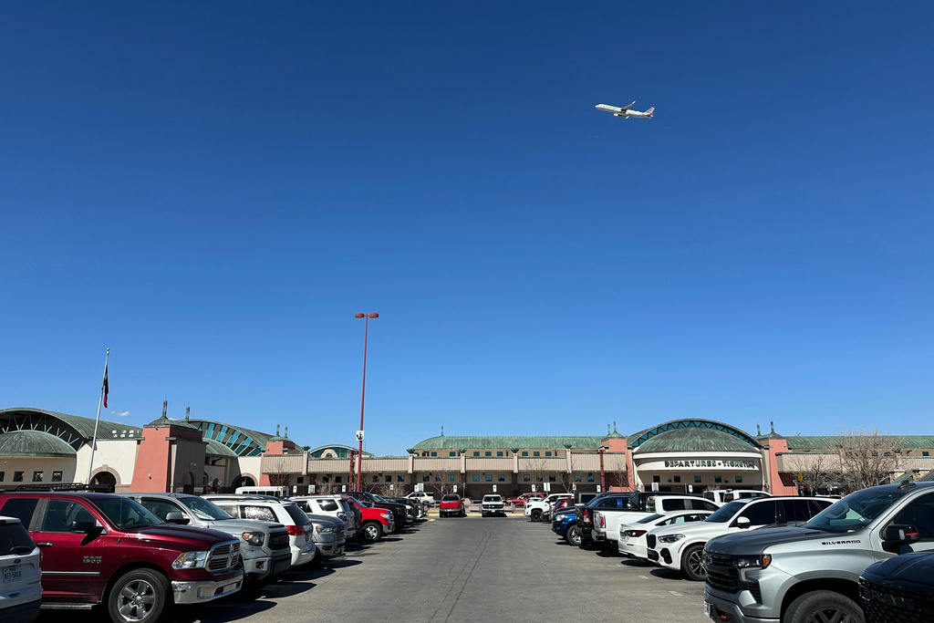 A plane flies over El Paso International Airport, Wednesday, Feb. 11, 2026, in El Paso, Texas. (AP Photo/Morgan Lee)