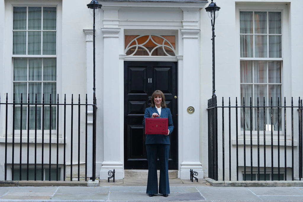 Britain's Chancellor of the Exchequer Rachel Reeves poses on the doorstep of 11 Downing Street with her ministerial red box before heading to the House of Commons to deliver her Budget speech in London, Wednesday, Nov. 26, 2025. (AP Photo/Kirsty Wigglesworth)