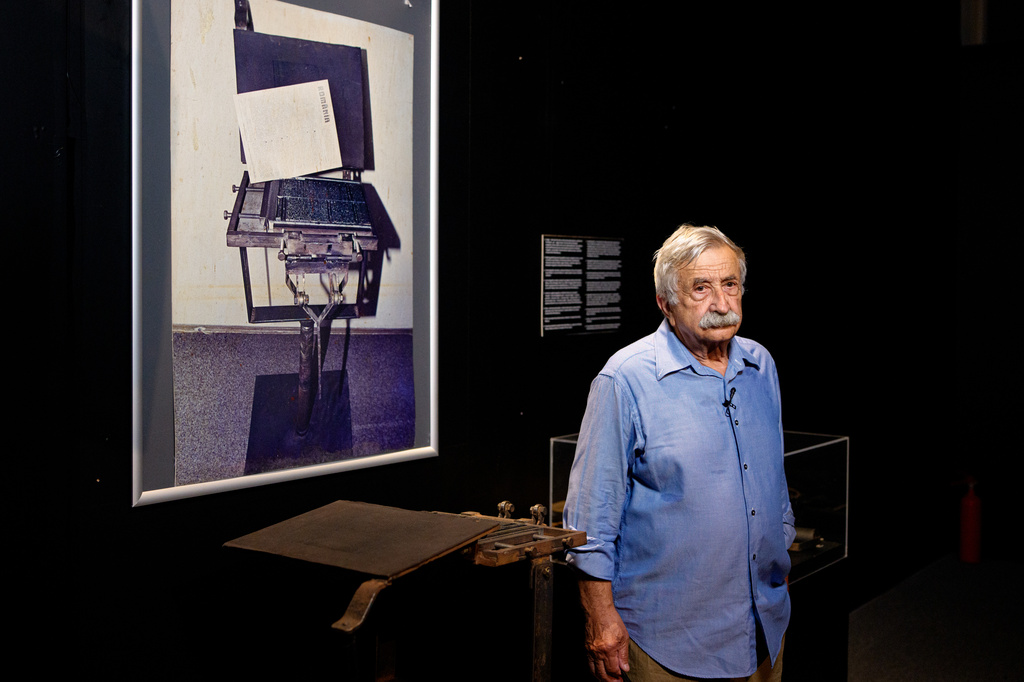 Journalist Petre Mihai Bacanu stands next to a clandestine printing press, belonging to him that was confiscated by the secret police in early 1989, during the opening of the "A.REST 1989 — The Securitate Video Archive" exhibition, at the National History Museum of Romania, in Bucharest, Romania, Tuesday, June 16, 2026. (AP Photo/Andreea Alexandru)