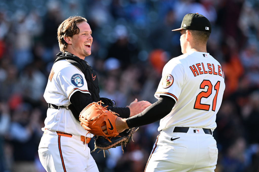 Baltimore Orioles catcher Adley Rutschman, left, and pitcher Ryan Helsley celebrate their 8-6 win over the Minnesota Twins in a baseball game, Sunday, March 29, 2026 in Baltimore. (AP Photo/Gail Burton)