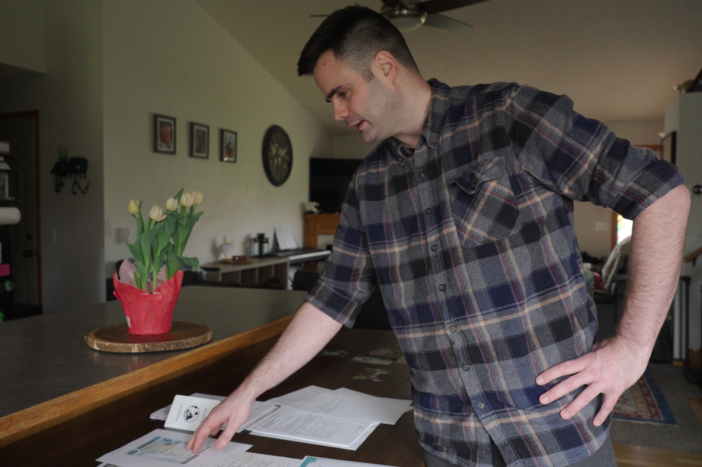 This image made from video shows Zach Loud looking through his application for Canadian citizenship at his family's home in Farmington, Minn., April 17, 2026. (AP Photo/Mark Vancleave)
