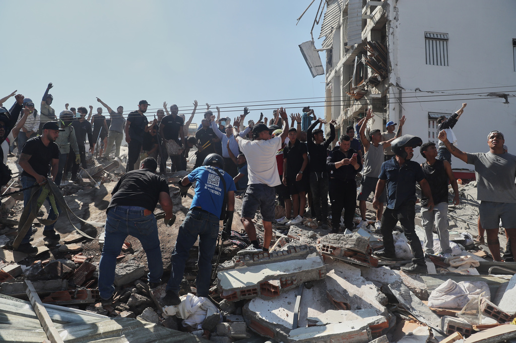 Residents and rescue workers search through the rubble of a collapsed building after an earthquake struck Cali, Colombia, Monday, Aug. 10, 2026. (AP Photo/Santiago Saldarriaga)
