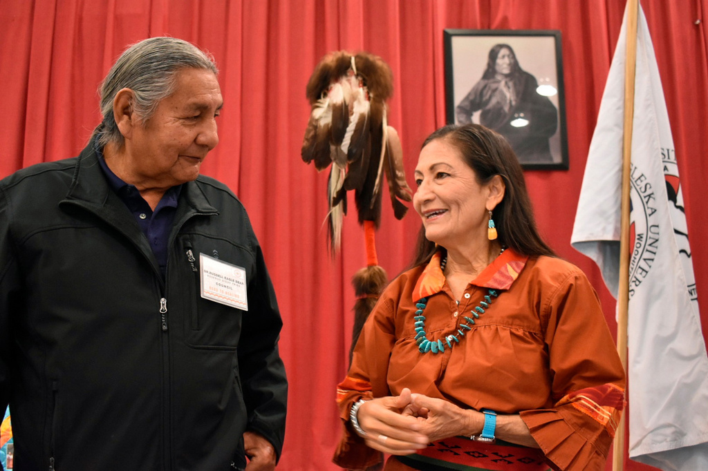 FILE - Russell Eagle Bear, left, with the Rosebud Sioux Reservation Tribal Council, talks to U.S. Interior Secretary Deb Haaland during a meeting about Native American boarding in Mission, S.D., on Oct. 15, 2022. (AP Photo/Matthew Brown, File)