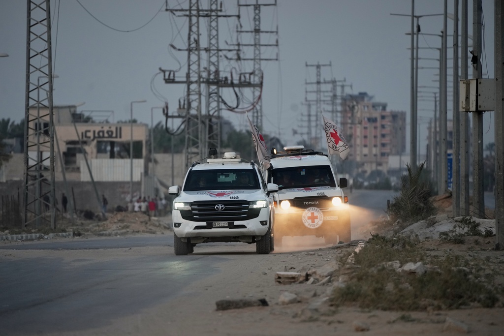 Red Cross vehicles carrying the bodies of two people believed to be deceased hostages handed over by Hamas make their way toward the Kissufim border crossing with Israel, to be transferred to Israeli authorities, in Deir al-Balah, central Gaza Strip, Thursday, Oct. 30, 2025. (AP Photo/Abdel Kareem Hana)