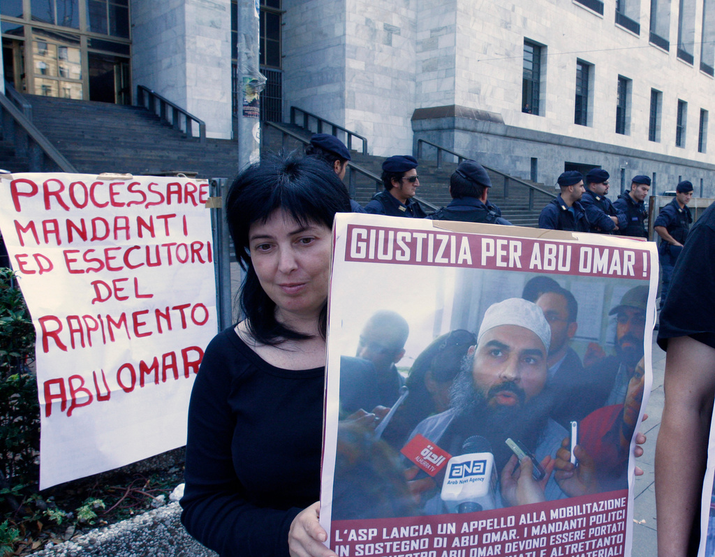 FILE - A protester holds up a poster with writing reading in Italian "Justice for Abu Omar" above a picture of Muslim cleric Osama Moustafa Hassan Nasr, also known as Abu Omar, outside Milan's court house while the trial of 26 Americans and seven Italians accused of orchestrating a CIA-led kidnapping of an Egyptian terror suspect Nasr was taking place inside the courtroom, in Milan, Italy, Wednesday, Sept. 23, 2009. (AP Photo/Luca Bruno, File)